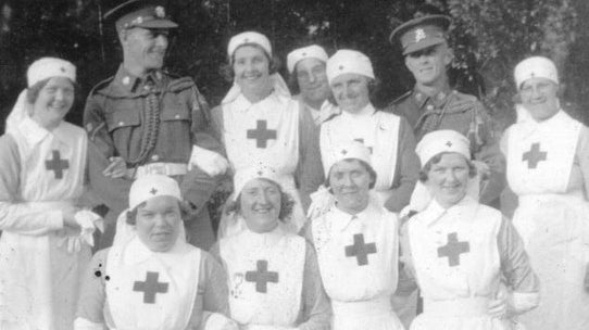 A photo of some volunteer British Red Cross nurses and two soldiers