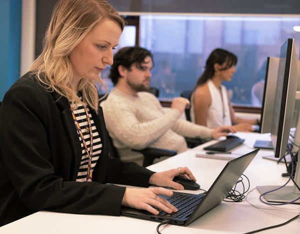 Three 26 employees sat at their desk and looking at their computer screen.