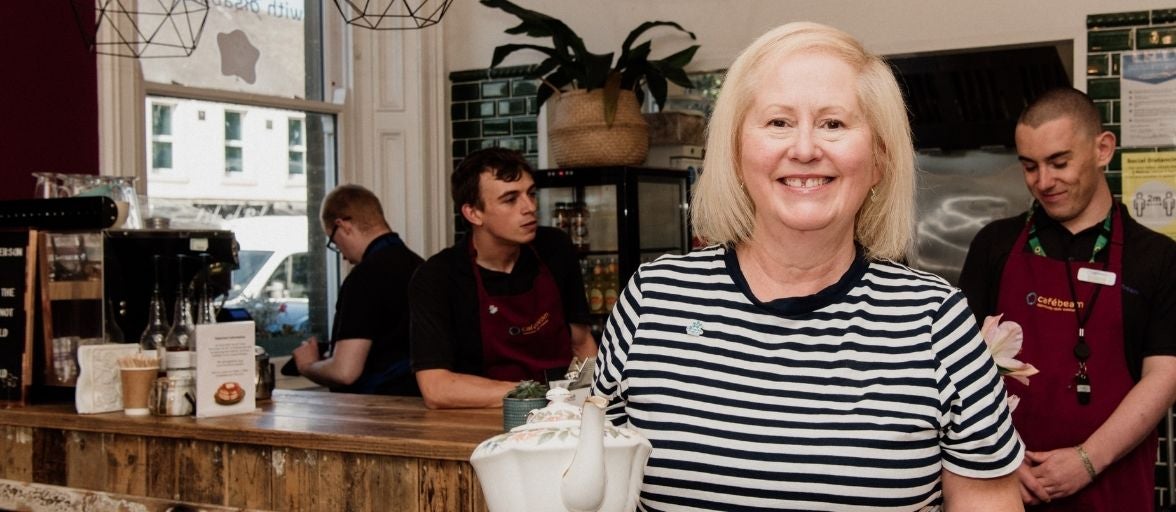 Sheila, stood with a pot of tea in the Smile for Life cafe in Gosforth