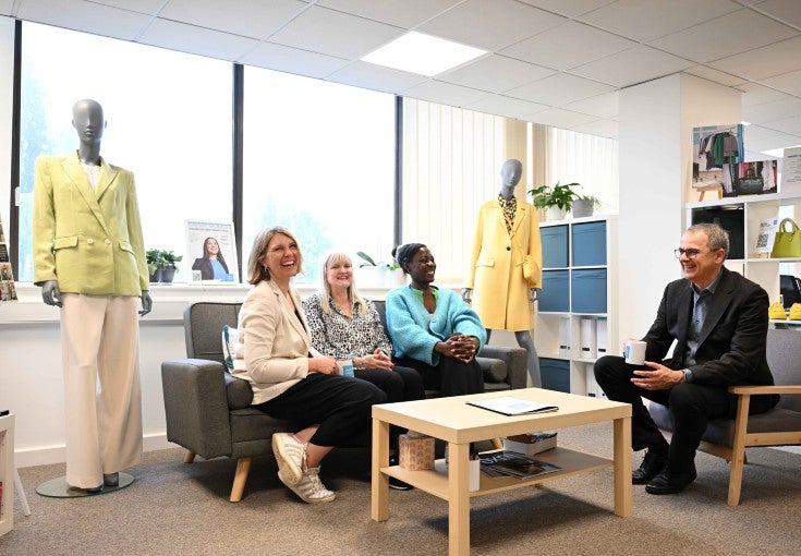 A group of people sitting on sofas in a room.