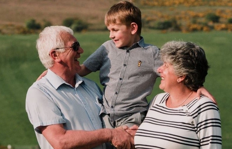 Grandparents holding their grandchild 