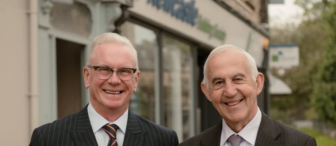 Two men stood outside of the Newcastle Building Society Hexham branch. 