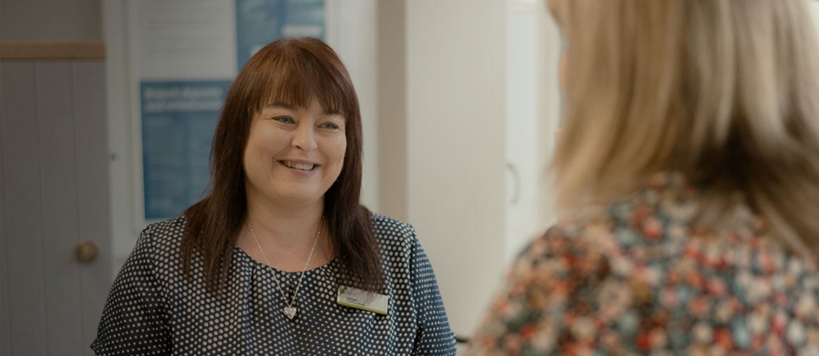 A Newcastle Building Society branch customer adviser smiling at a customer. 