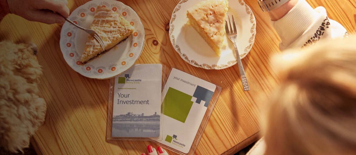 Newcastle Building Society passbooks lying on a table, surrounded by two plates with slices of pie on them.
