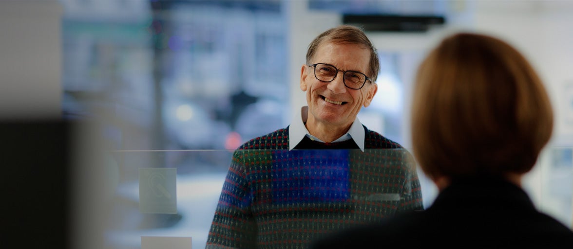 Man smiling at a lady stood behind a counter - DO NOT USE