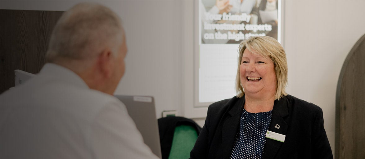 A Newcastle Building Society customer adviser speaking with a customer at the front desk in the West Denton branch. 