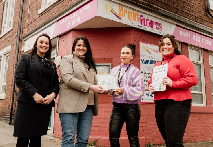 Our South Shields Assistant Branch Manager and Head of IT Delivery presenting a community plaque to two ladies from the charity, Bright Futures. All four ladies are stood outside of Bright Futures' headquarters. 