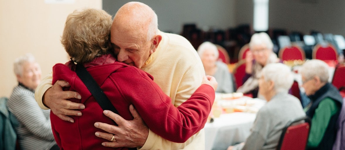 Two Mind Active service users hugging at their Christmas lunch club event