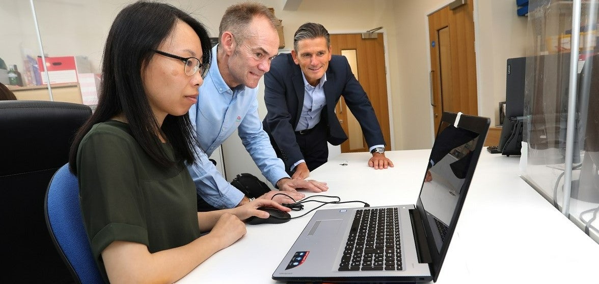 A Newcastle Building Society representative with two Search Newcastle representatives looking at a laptop.