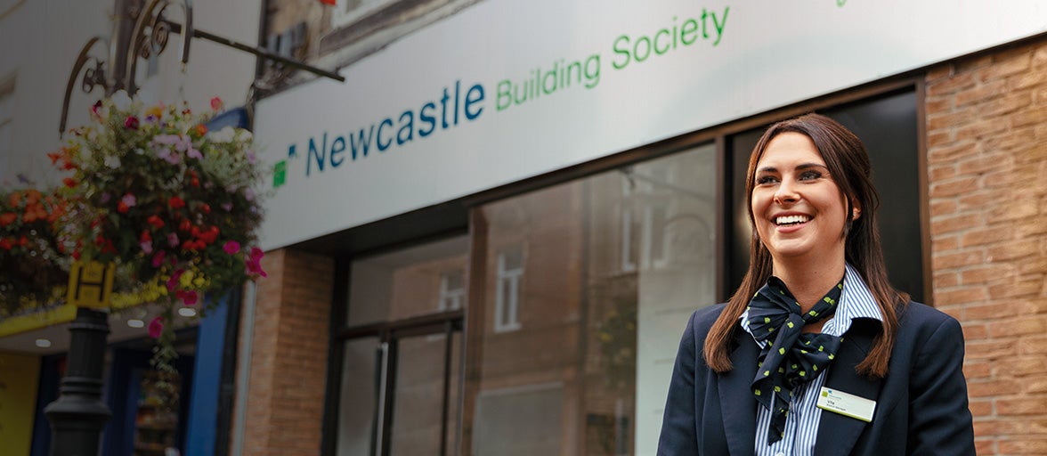 Lady stood in front of Newcastle building society shop in Bishop Auckland, smiling at camera. 