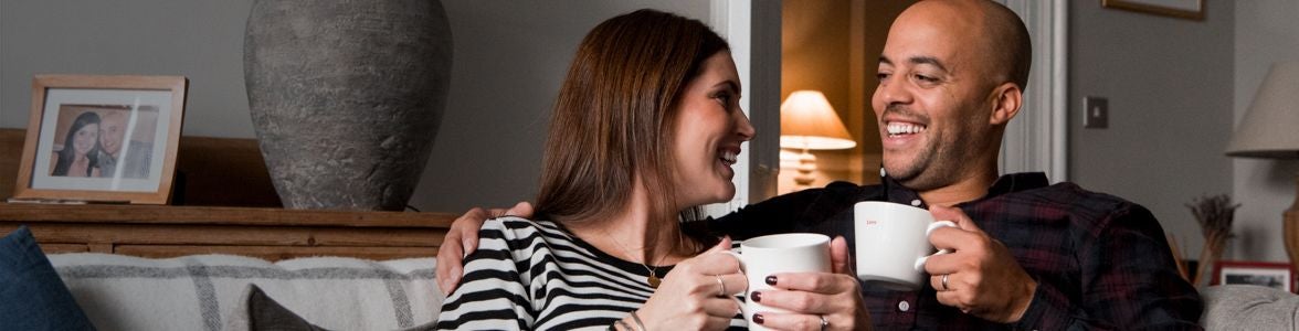 Man and woman having a cup of coffee on the sofa