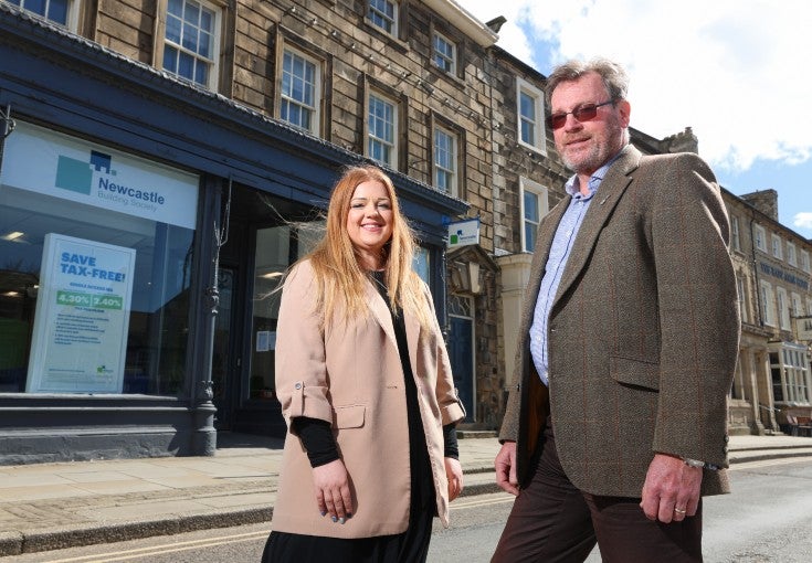 A man and woman stood outside of a building society branch.
