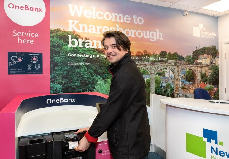 Nathan, the Store Manager at The Music Bank in Knaresborough, using the OneBanx kiosk in our Knaresborough Branch.