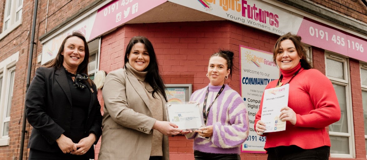 Our South Shields Assistant Branch Manager and Head of IT Delivery presenting a community plaque to two ladies from the charity, Bright Futures. All four ladies are stood outside of Bright Futures' headquarters.