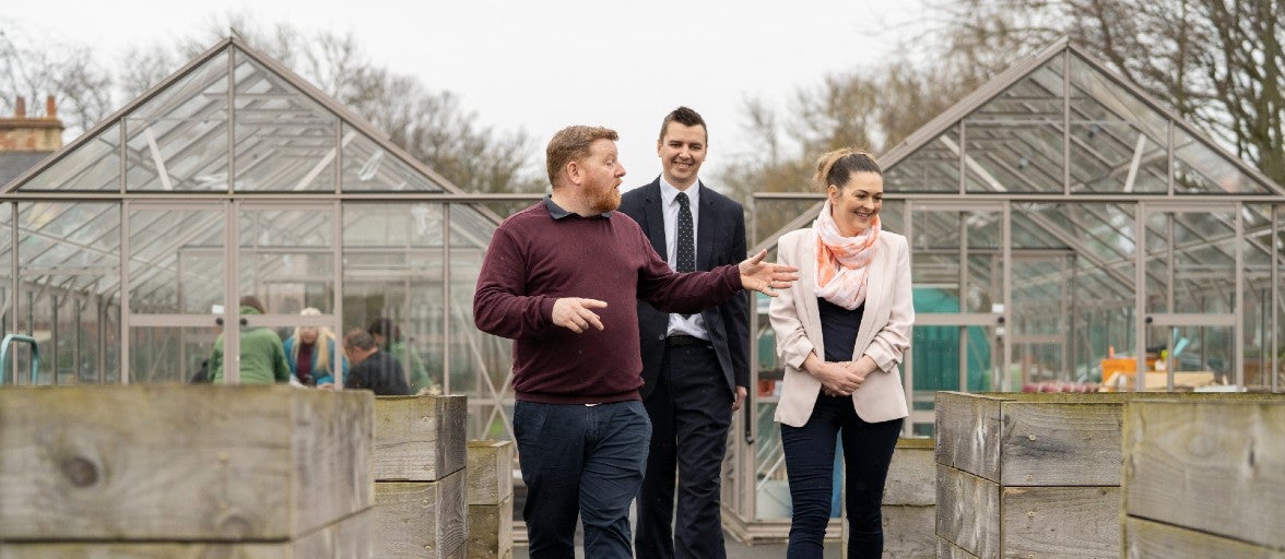 The Operations Manager at Full Circle Food Project showing two Newcastle Building Society colleagues around the centre's community garden.