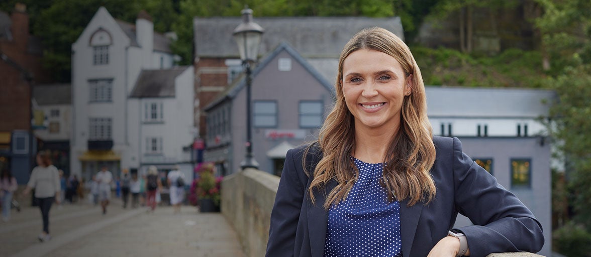 Durham Branch Manager, Faye Dale, stood on a bridge in Durham city centre. 