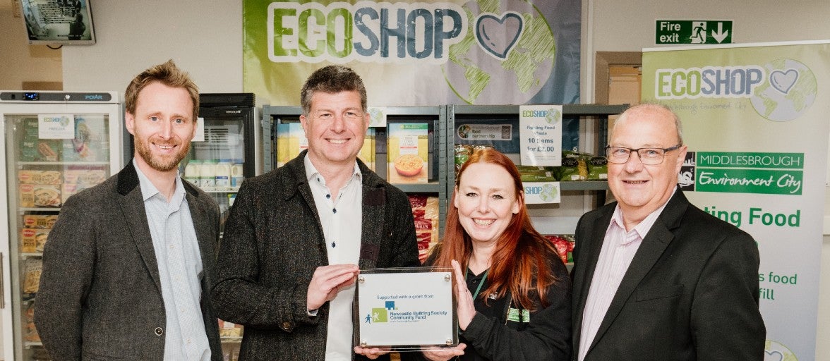 Karl Elliott, Brand and Marketing Director at Newcastle Building Society, with three Middlesbrough Environment City representatives in their Eco-Shop, holding a Community Fund plaque.