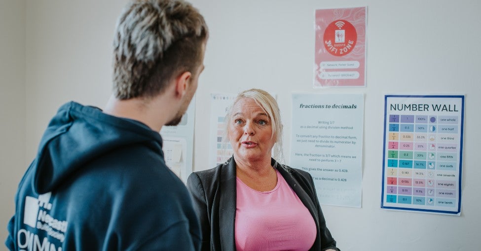 The Centre Manager at the Parker Trust stood talking to a Newcastle Building Society volunteer.