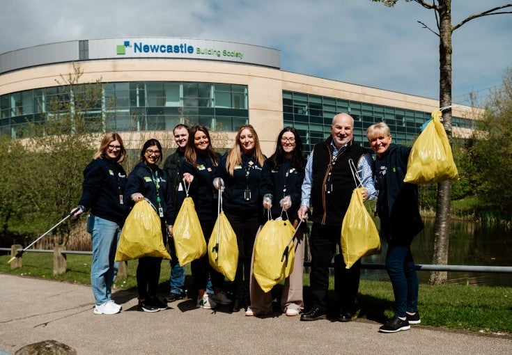 Colleagues posing with litterpickers and bin bags outside of Newcastle Building Society's head office.