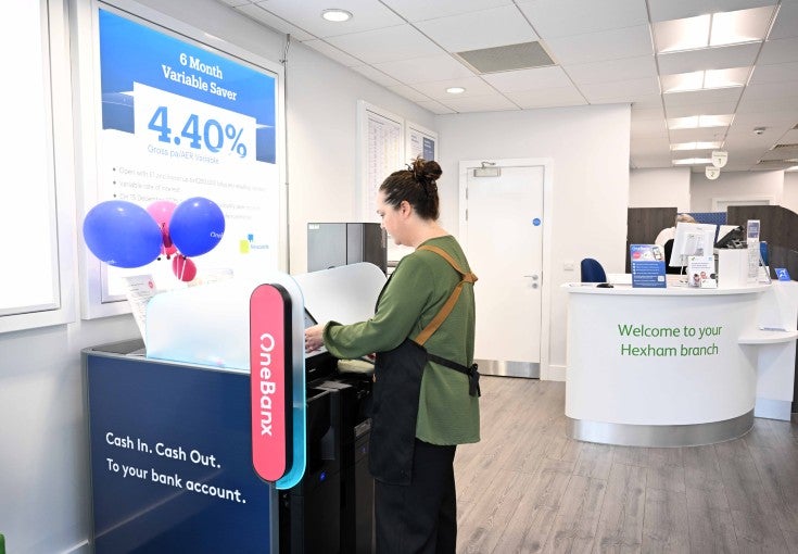 A lady using the OneBanx kiosk in Newcastle Building Society's Hexham branch.
