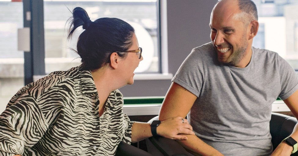 Two Solutions colleagues laughing in a break out area