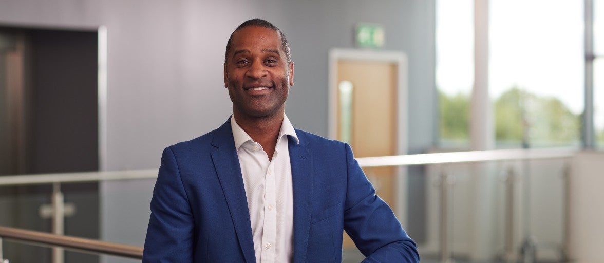 Newcastle Building Society's non-executive director, Rory Campbell, stood on a balcony inside their Cobalt head office, smiling at the camera.