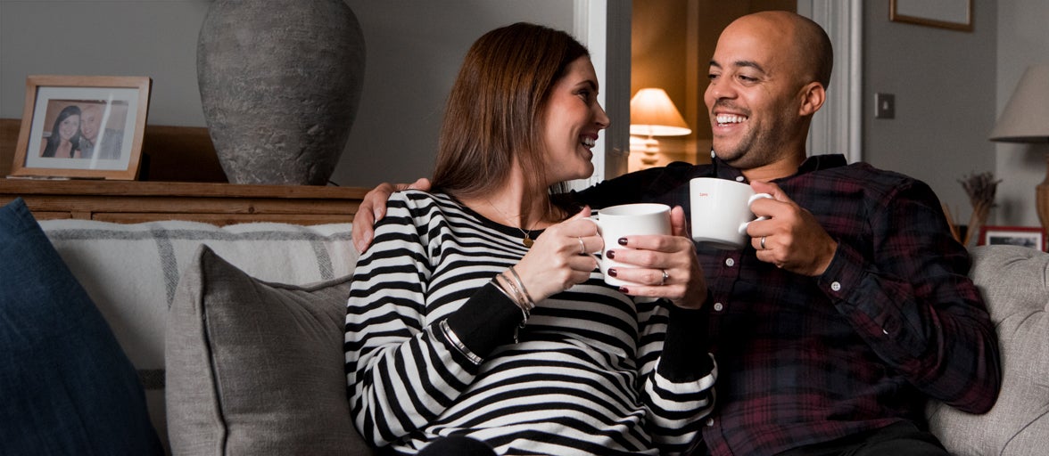 Man and woman having a cup of coffee on the sofa