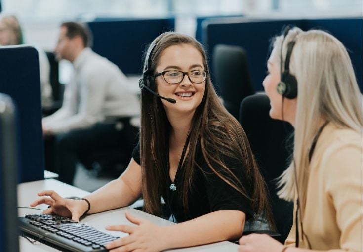 Two colleagues sat at a computer desk in our Head Office