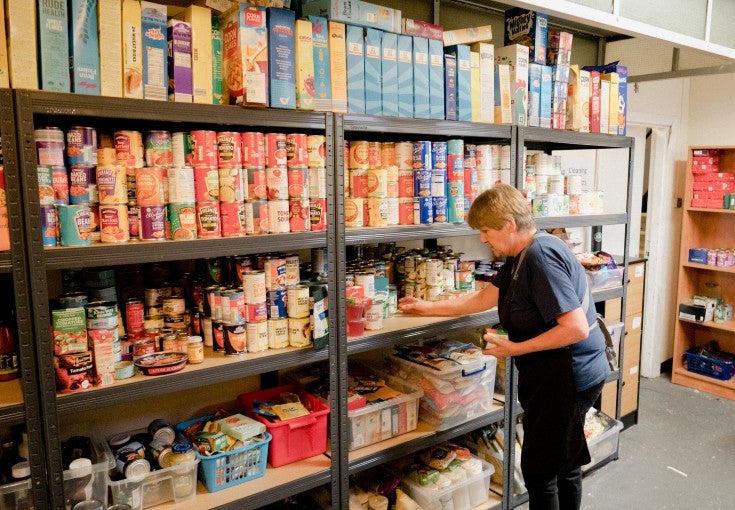 A St Vincent's volunteer re-stocking the shelves at their foodbank larder.