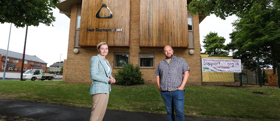 A man and a woman post outside the EasTwo people stand outside the East Durham Trustt Durham Trust building.