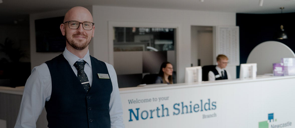 North Shields Branch Manager, Conor King stood inside the branch in front of the reception desk, smiling. 