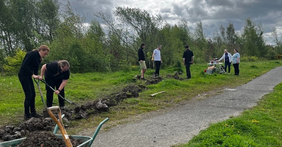 Our Product & Commercial team volunteering at Pegswood Community Park, digging trenches to improve rain flow.