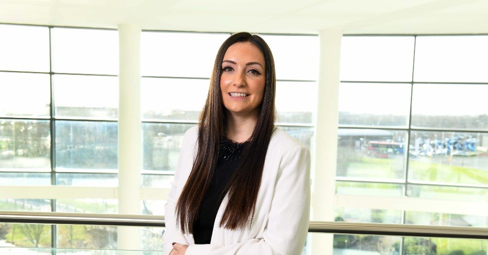 Our Head of Diversity, Equality and Inclusion, Jennie Pitt, leaning against a railing and smiling for the camera. 