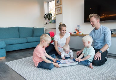 A family play a game on the floor of their home
