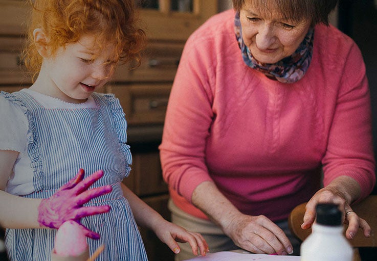 Little girl and her Grandmother doing arts and crafts at home.