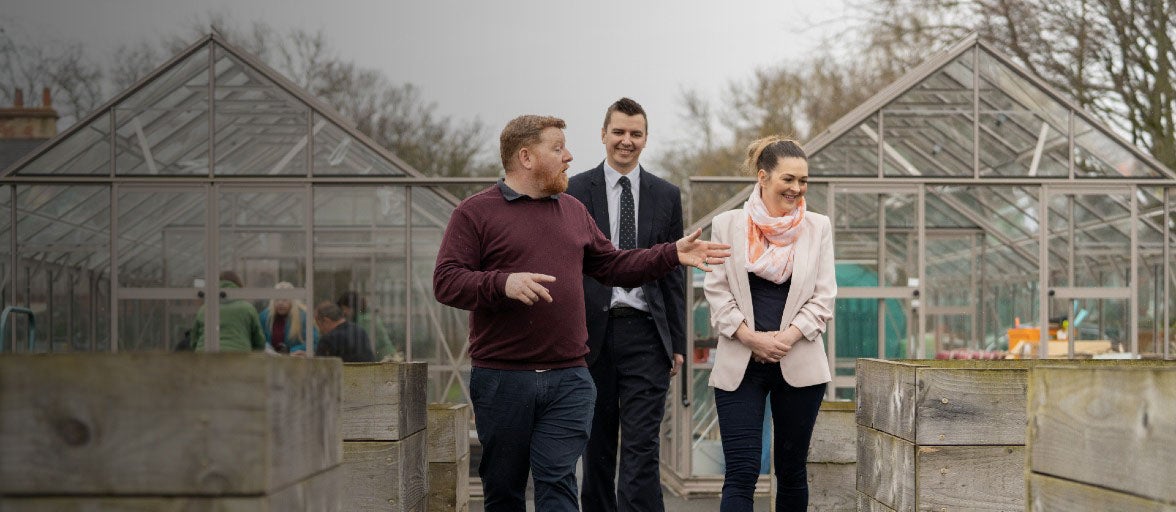 The Operations Manager at Full Circle Food Project showing two Newcastle Building Society colleagues around the centre's community garden.