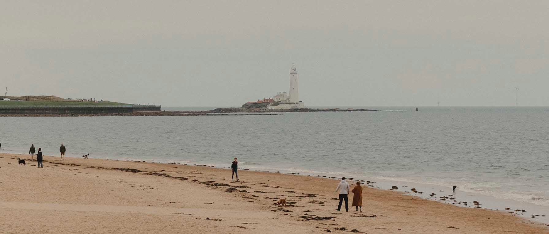 Whitley Bay beach, with a light house in the distance.
