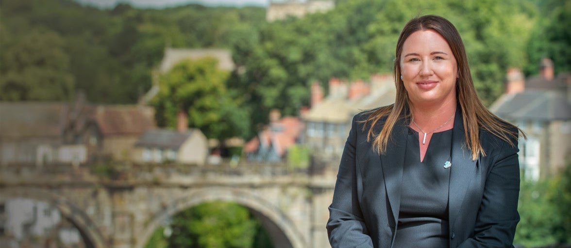 Knaresborough branch manager stood outside near a bridge.