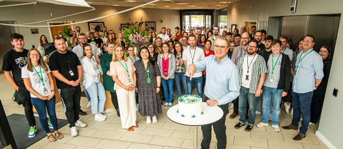 A large group of Newcastle Building Society colleagues gathered in their head office reception area for a celebratory cake cutting.