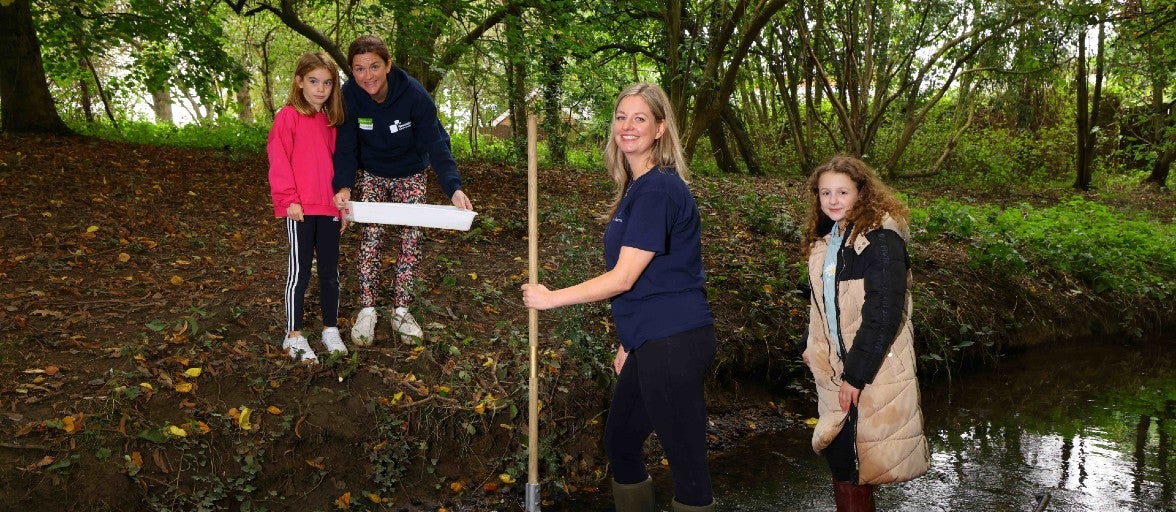 A group of people standing in a stream.