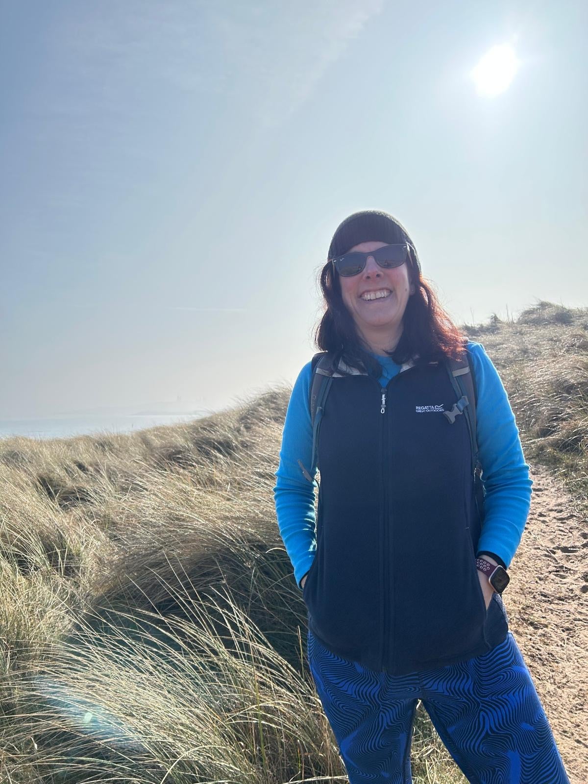 Image of women in sand dunes smiling.