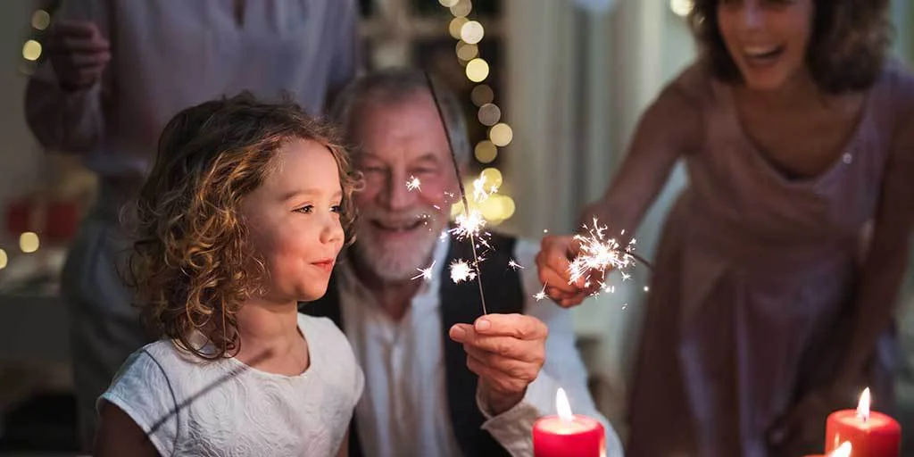 Granddad playing with sparklers with his granddaughter