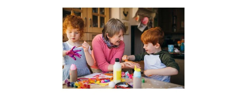 Grandmother finger painting with her grandkids