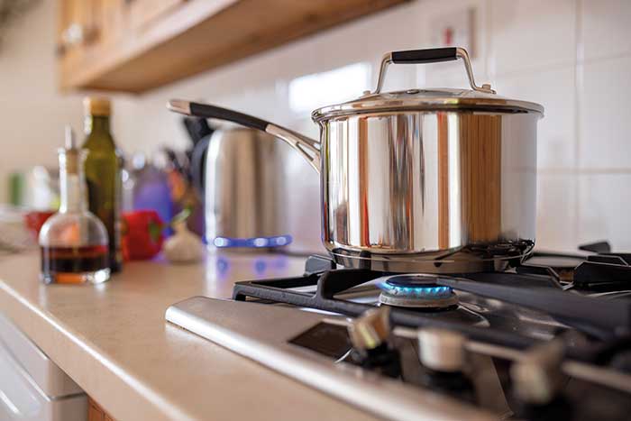 Saucepan with lid on a lit gas hob