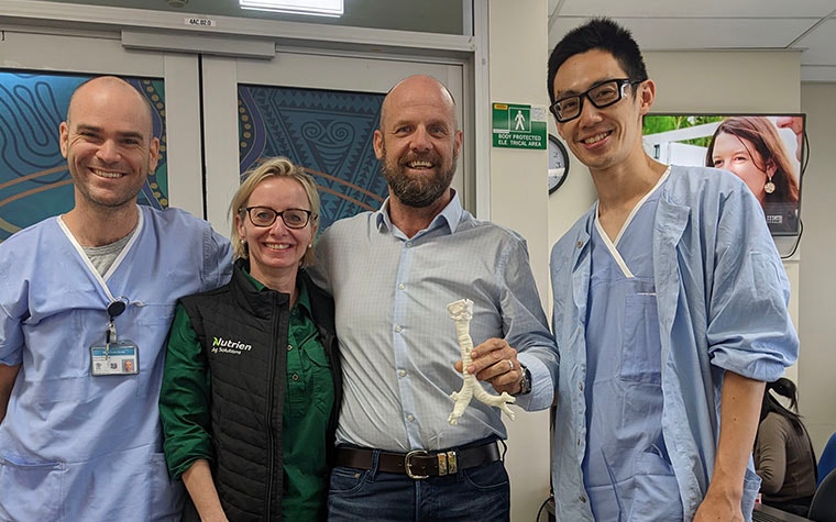 The doctors and the patient's wife and the patient smiling while holding a 3D-printed model.