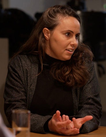 Kristel Van den Bergh sitting at a table and speaking