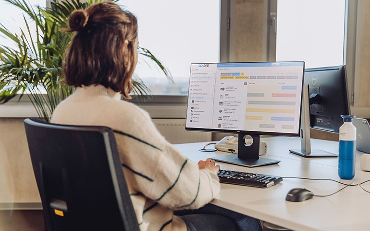 Femme assise à un bureau utilisant le logiciel Materialise