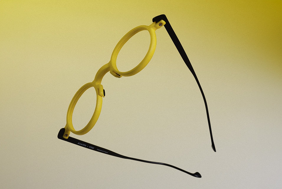 A pair of yellow 3D-printed Acuitis frames against a yellow background