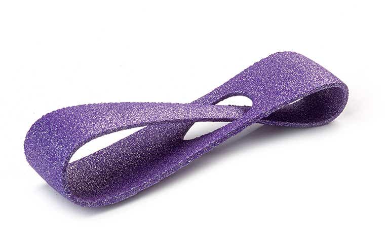 Eine glitzernde violette 3D-gedruckte Schlaufe aus PA-AF (aluminiumgefüllt), die im Lasersinterverfahren hergestellt und farbig eingefärbt wurde.