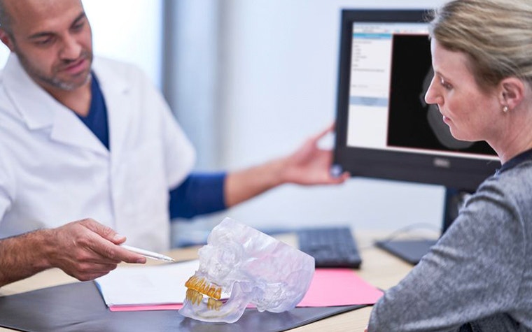 CMF surgeon explaining CMF pathology to a patient using an anatomical model 